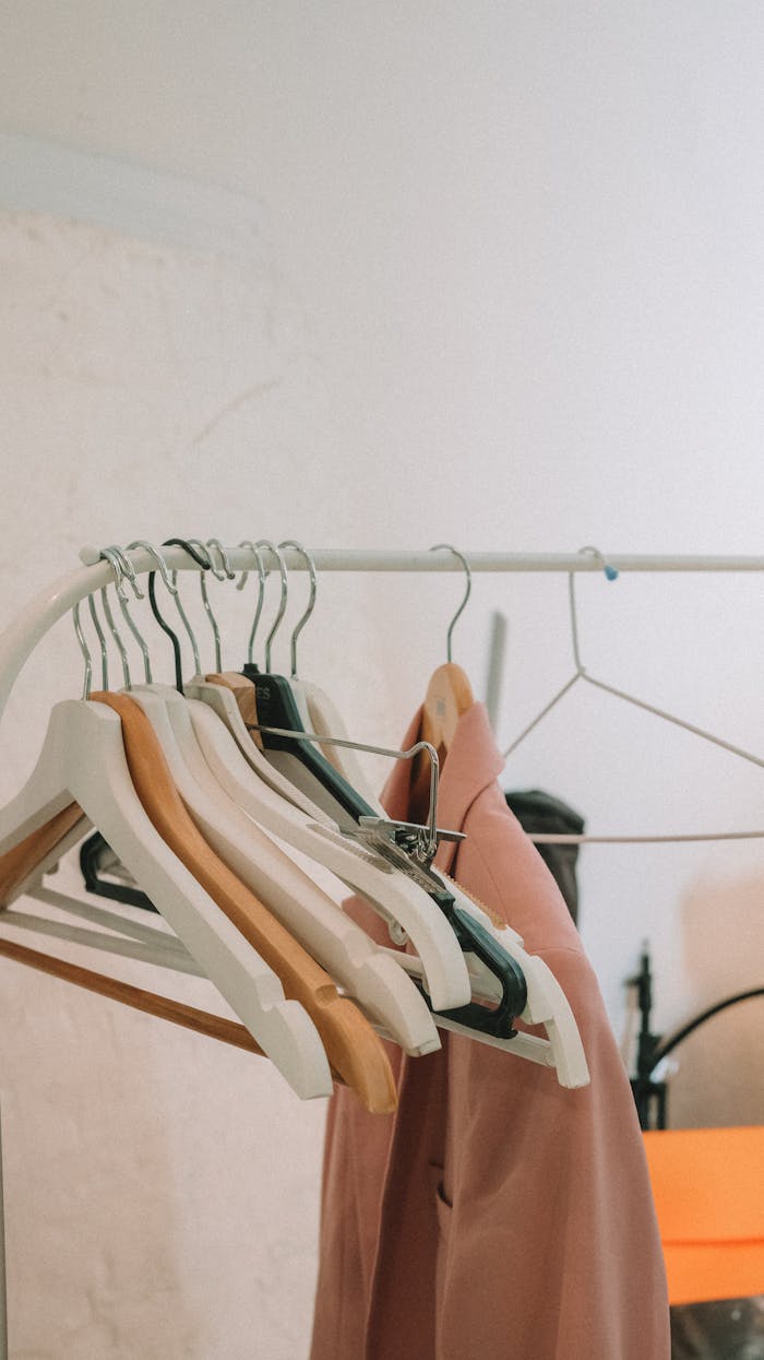 Elegant blazers hanging on a modern clothes rack indoors, perfect for fashion and retail themes.